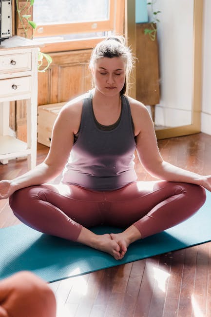 Woman practicing quiet yoga in a bright, peaceful room.